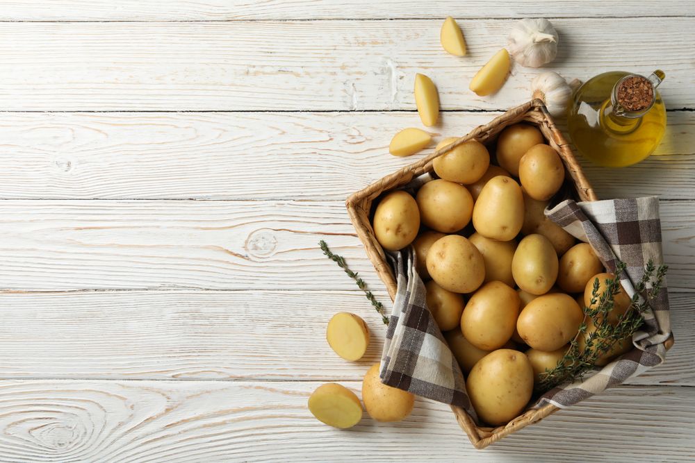 Looking down at box of potatoes on rustic background, copy space