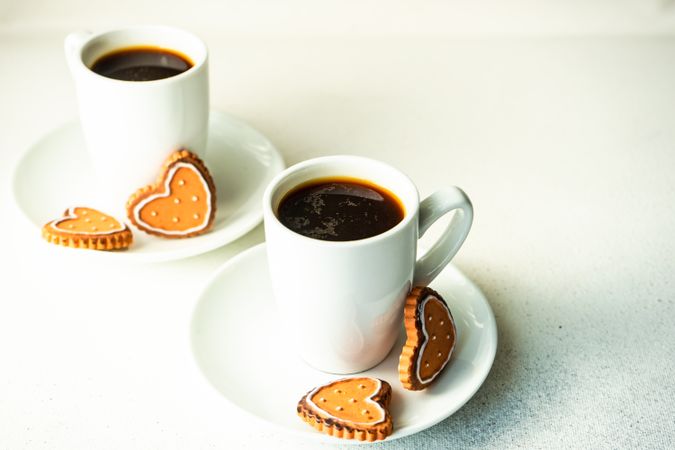 Two espressos served with heart sugar cookies