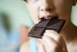 Girl biting into dark chocolate