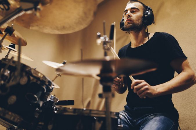 Man with headphones playing on drums