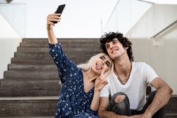 Happy couple taking selfie on street