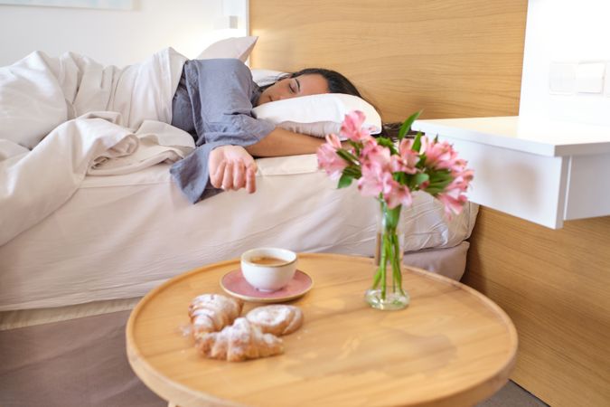 Asleep female on bed near table with mug of coffee