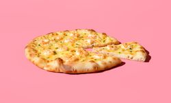 Sliced shrimp pizza minimalist on a vibrant pink table