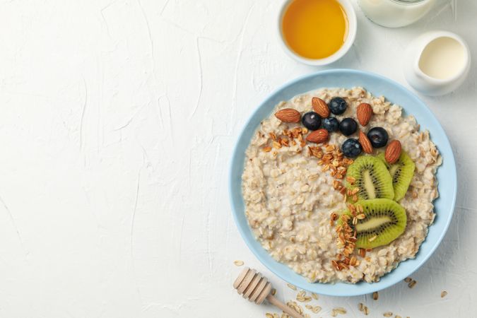Composition with oatmeal with fruits on blank background