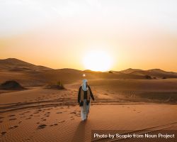 Woman walking in the desert during golden hours 5qoxab