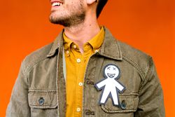 Smiling man with funny paper toy on jean jacket