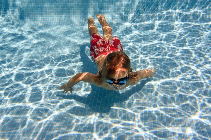Boy swimming near bottom in pool