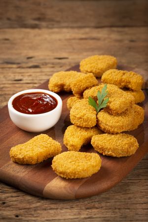 Fried chicken nuggets with ketchp and rose sauce.