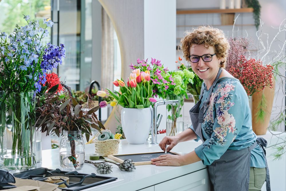 Positive mature woman working in floral shop