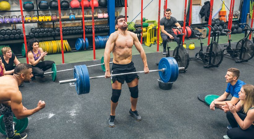 Strong man practicing weightlifting in a fitness center