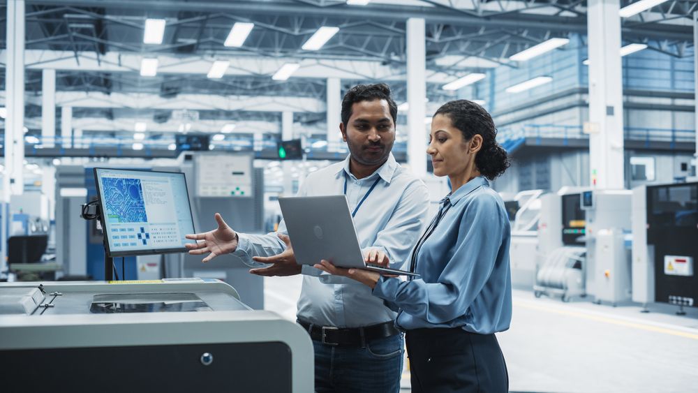 Male and female colleagues with computer at store check out