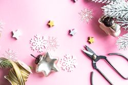 Top view of Christmas decorations of snowflakes and stars on pink background