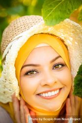 Portrait of woman in yellow hijab and straw hat smiling 5a8AK0