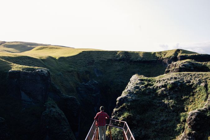 Man on ledge over epic landscape