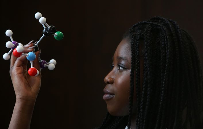Young woman looks at organic chemistry structure