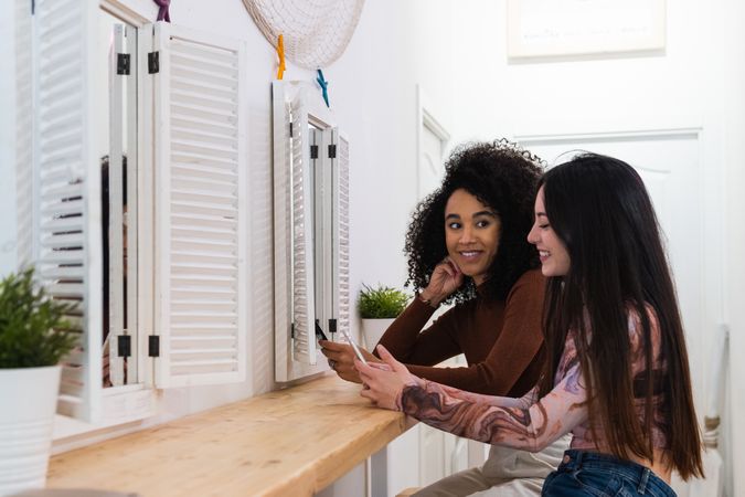 Happy multiracial women chilling together in bar