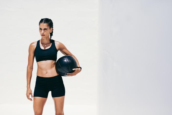 Portrait of female trainer standing with medicine ball