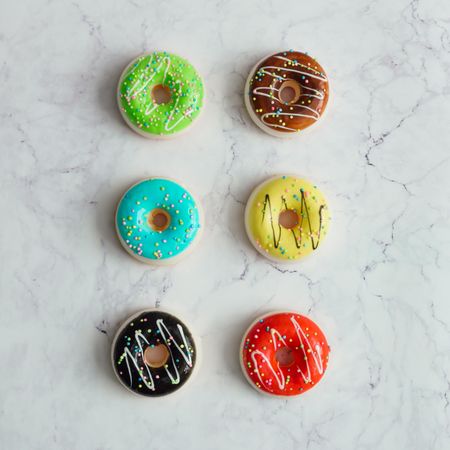 Rows of colorful donuts on marble background