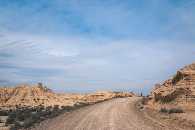 Man walking on road in desert hills