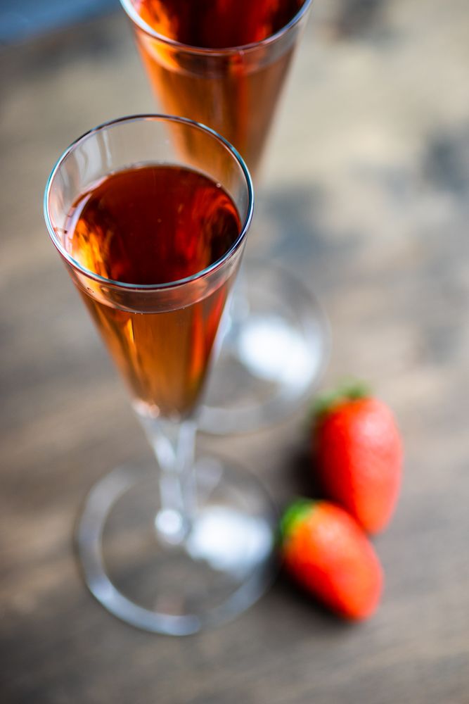 Pink champagne in flutes with strawberry garnish