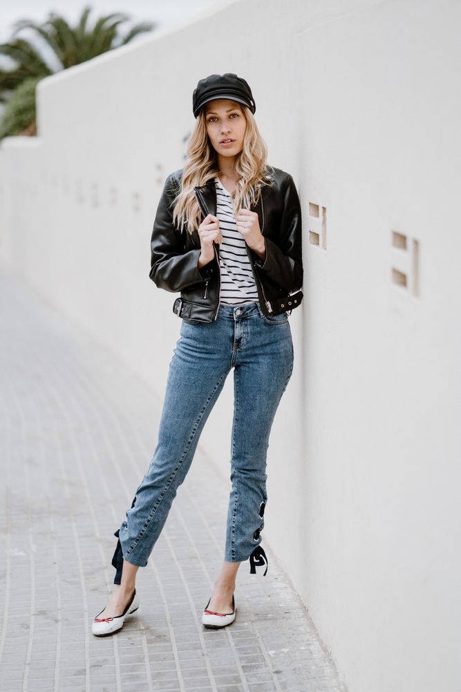 Stylish woman confidently leaning on white wall