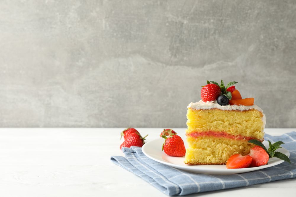 Composition with delicious berry cream cake against gray background. Tasty dessert