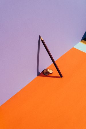 Pencil and shavings from sharpening, leaning on the violet wall.