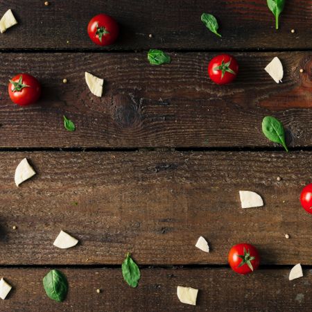 Basil, tomatoes, and cheese on wooden background