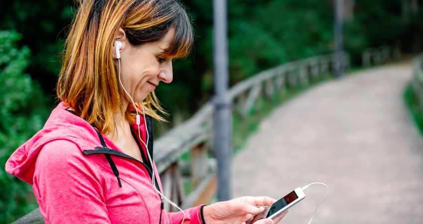 Athlete woman with earphones looking mobile