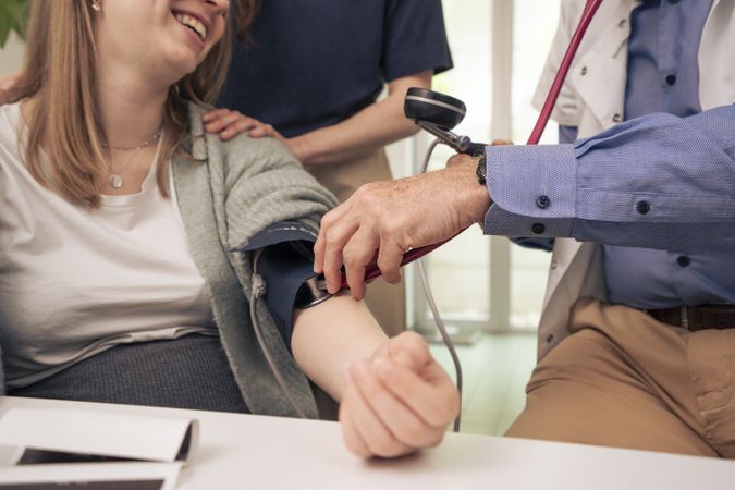 Doctor measuring blood pressure of a pregnant woman during a check-up.