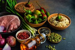 Pork cutlets in bowl surrounded by ingredients for dinner