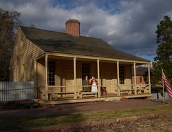 Man and woman on porch of traditional 18th Century home, Colonial Williamsburg, Virginia