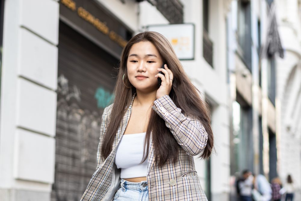 Young Asian woman talking on the phone in the city