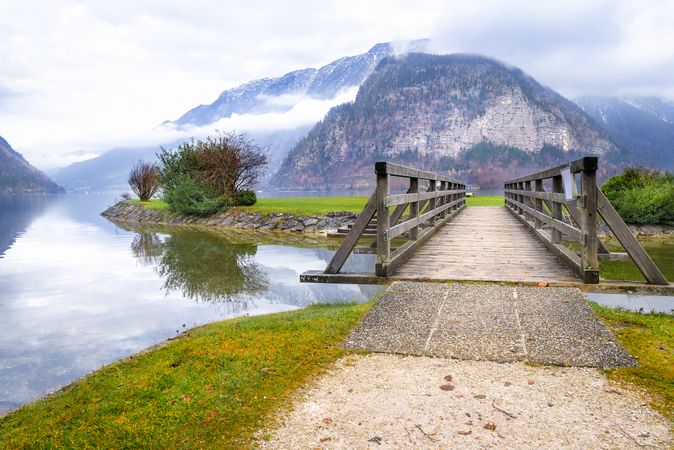 Bridge over lake with Austrian Alps in background