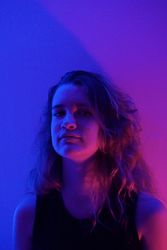 Portrait of blonde teenage girl in purple lit studio