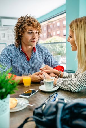 Couple holding hands at a cafe