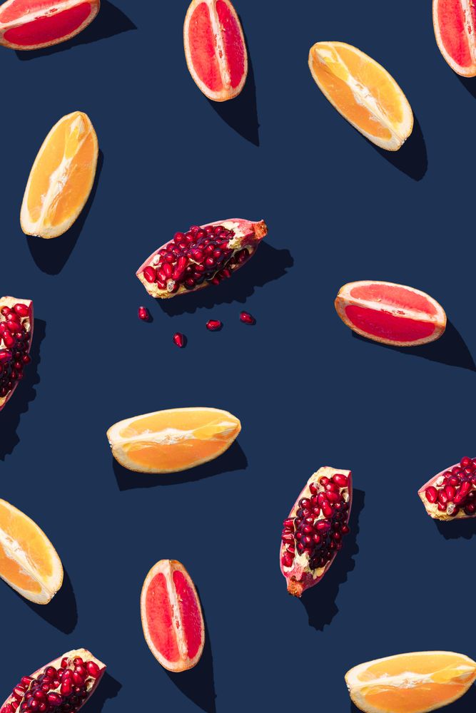 Pattern of grapefruit, orange, pomegranate and lemon slices on navy background