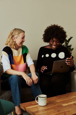 Two women working on laptop while brainstorming