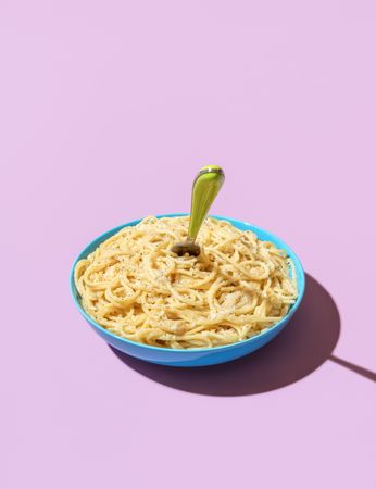 Cheese spaghetti bowl isolated on a purple background