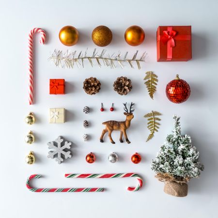 Christmas layout made of festive decorations, baubles, candy canes, presents on light background