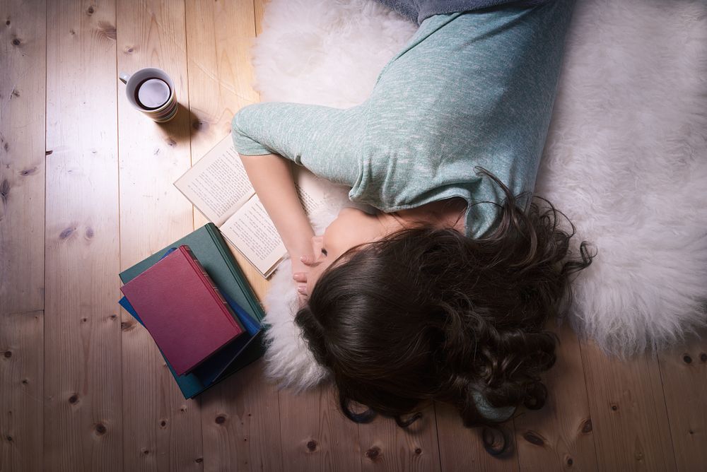 Young woman sleeping on an open book