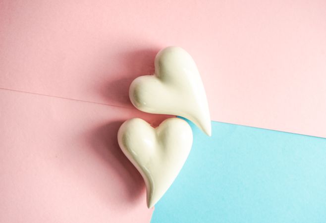Ceramic heart ornaments on blue and pink pastel table 