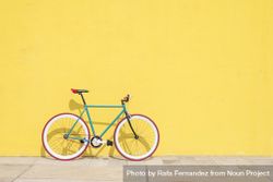 Full bike outside on bright yellow wall 0Jrxn0