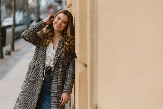 Woman leaning on wall on street