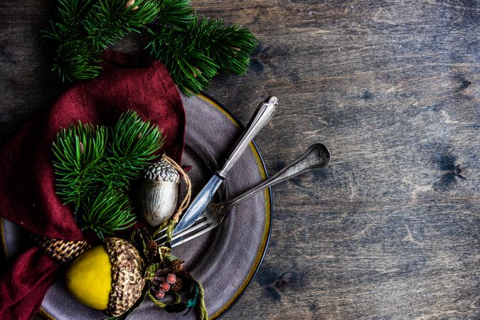 Plate with Christmas ornaments on wooden table