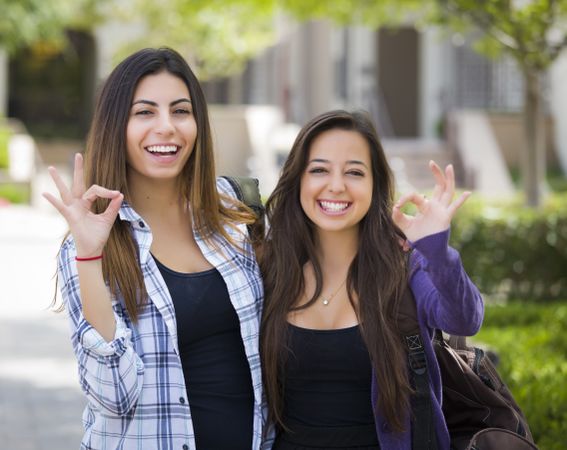 Female Students on School Campus With Okay Sign