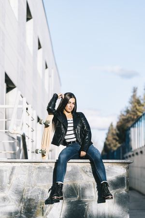 Young woman posing with skateboard