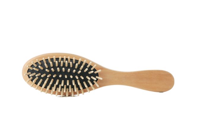 Wooden hair brush isolated on light background