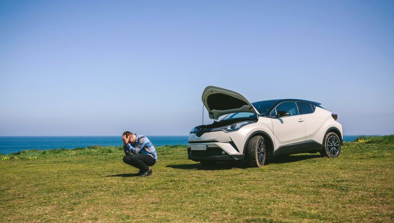 Young man desperate, car broken down