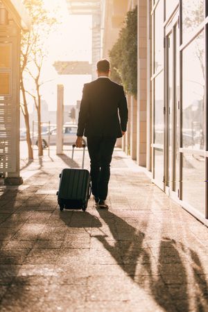 Young business traveler with suitcase outside airport